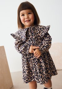 Leopardenmuster Kleid mit gerafftem Kragen und Ärmeln, verziert mit rosa Knöpfen. Hergestellt aus einem strukturierten Stoff mit einem gerafften Taillenbund.