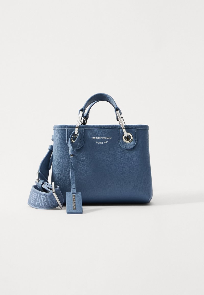 Modra usnjena torbica s strukturirano obliko, dvema kratkima ročajema, snemnim trakom, srebrno obdelavo in vtisnjenim blagovno znamko.