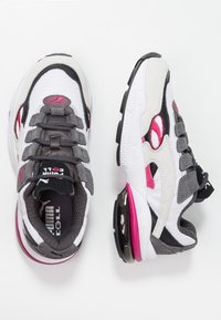 Baskets de course Puma blanches, grises et rose en matériaux mesh et daim, avec un amorti d'air visible et des lacets noirs, présentées en vues de dessus et de côté.