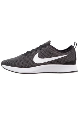 Czarno-szary but do biegania Nike z białym logo Swoosh, czarnymi sznurowadłami i grubą białą podeszwą, widoczny z boku.