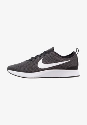 Czarno-szary but do biegania Nike z białym logo Swoosh, czarnymi sznurowadłami i grubą białą podeszwą, widoczny z boku.