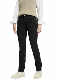 Jeans negros ajustados con un diseño clásico, fabricados en tejido de mezclilla. Con bolsillo frontal, cremallera y detalle de botón metálico.