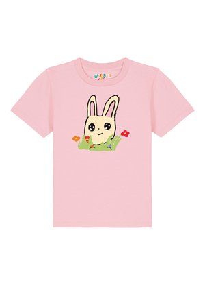 Roze katoenen t-shirt met een cartoon konijnontwerp omringd door kleurrijke bloemen en kleine voorwerpen, met korte mouwen en een ronde hals.