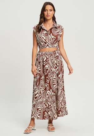 Ensemble deux pièces brunes et crème, à motifs, comprenant un haut cropped avec col et une jupe fluide taille haute à coupe décontractée.