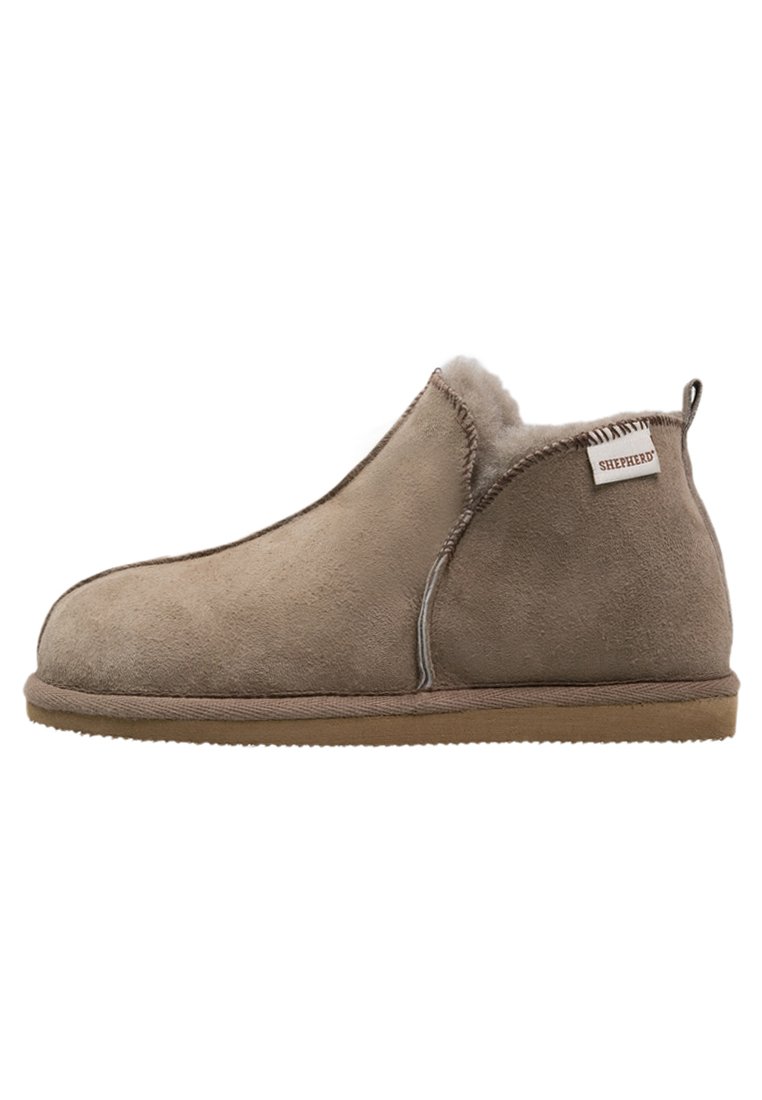 Beige semsket ankelstøvel med myk pelsforing, sømdetaljer og gummisåle. Har en merklabel på siden med "SHEPHERD."
