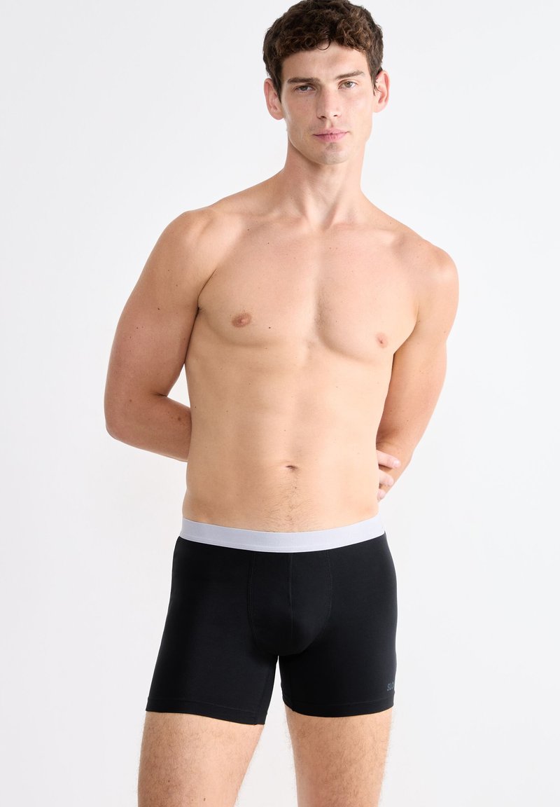 Boxer briefs neri con un elastico grigio in vita, caratterizzati da una texture liscia e un design aderente, oltre a un sottile dettaglio con logo.