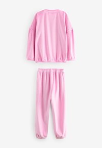 Survêtement en polaire rose avec un col rond et des manches bouffantes. Taille élastique sur le pantalon, présentant une texture lisse et une coupe décontractée.