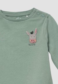 Groene langemouwen shirt gemaakt van zachte stof, met een geborduurde ezelgezicht met details en het woord "Ezel" eronder.
