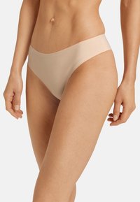 Beige naadloze hipsterondergoed met een zachte textuur en een minimalistisch ontwerp, met een laaghangende tailleband voor een comfortabele pasvorm.