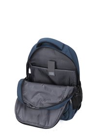 Sac à dos en tissu bleu avec un intérieur spacieux gris, plusieurs compartiments et une fermeture éclair. Dispose d'une poignée et de bretelles ajustables.