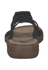 Svarta sandaletter med remmar som har en mjuk, brun sula. Den strukturerade sulan ger bra grepp, med förstygn runt kanterna.