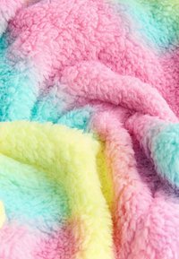 Fuzzy kastetæppe med en pastel regnbuegradient i pink, mint og gul farver samt en blød, fluffy tekstur.