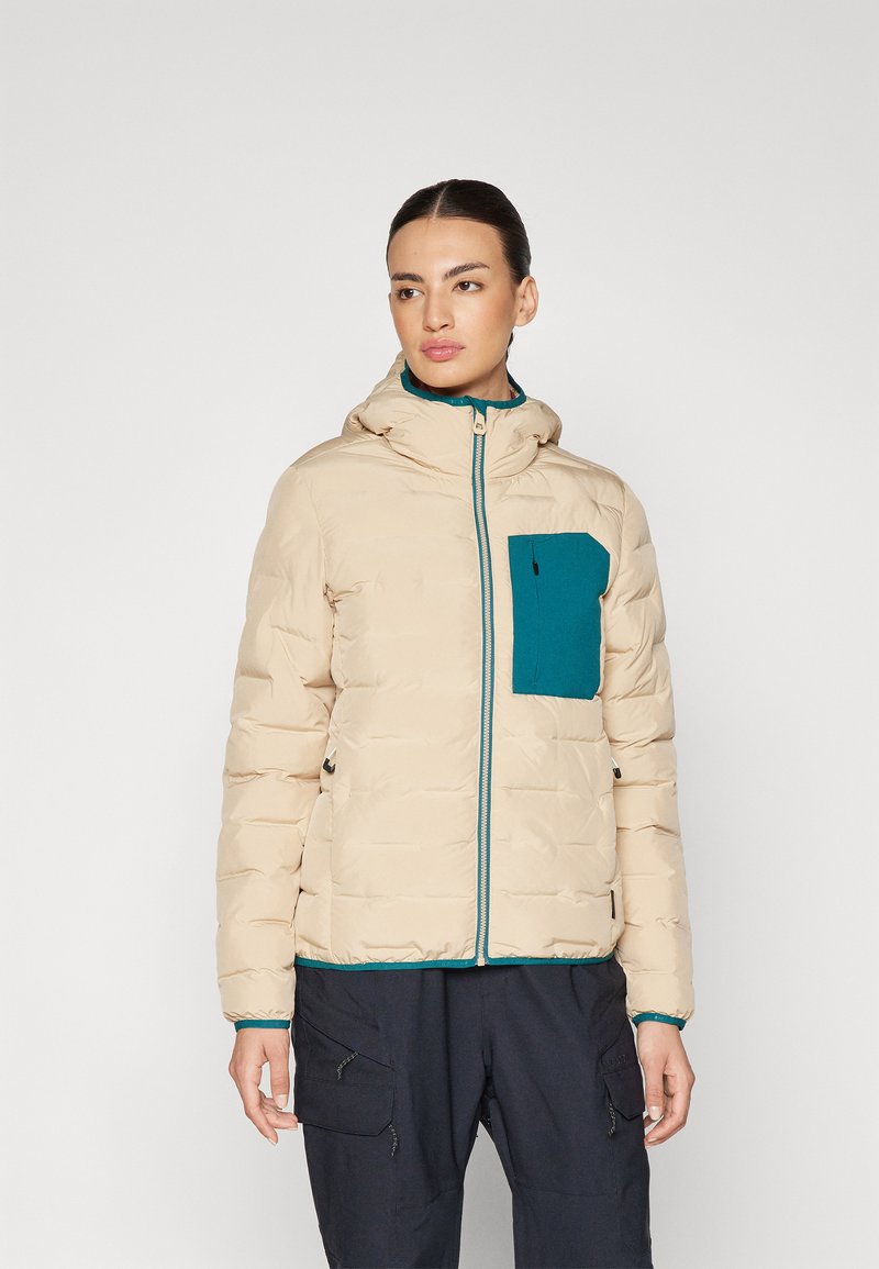 Beige dunjakke med en teal brystlomme, frontlukking med glidelås og hette. Har quiltet tekstur og kontrastfargede blå detaljer.