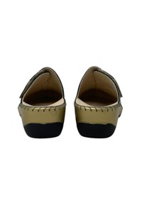 Scarpe color oro con una superficie liscia, dettagli cuciti lungo il bordo e suole nere. Con apertura sul retro e un leggero design del tacco.