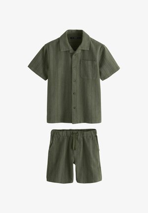 Chemise boutonnée à manches courtes de couleur vert olive avec poche poitrine, accompagnée d'un short assorti à taille élastique, doté d'un cordon de serrage et de poches latérales.