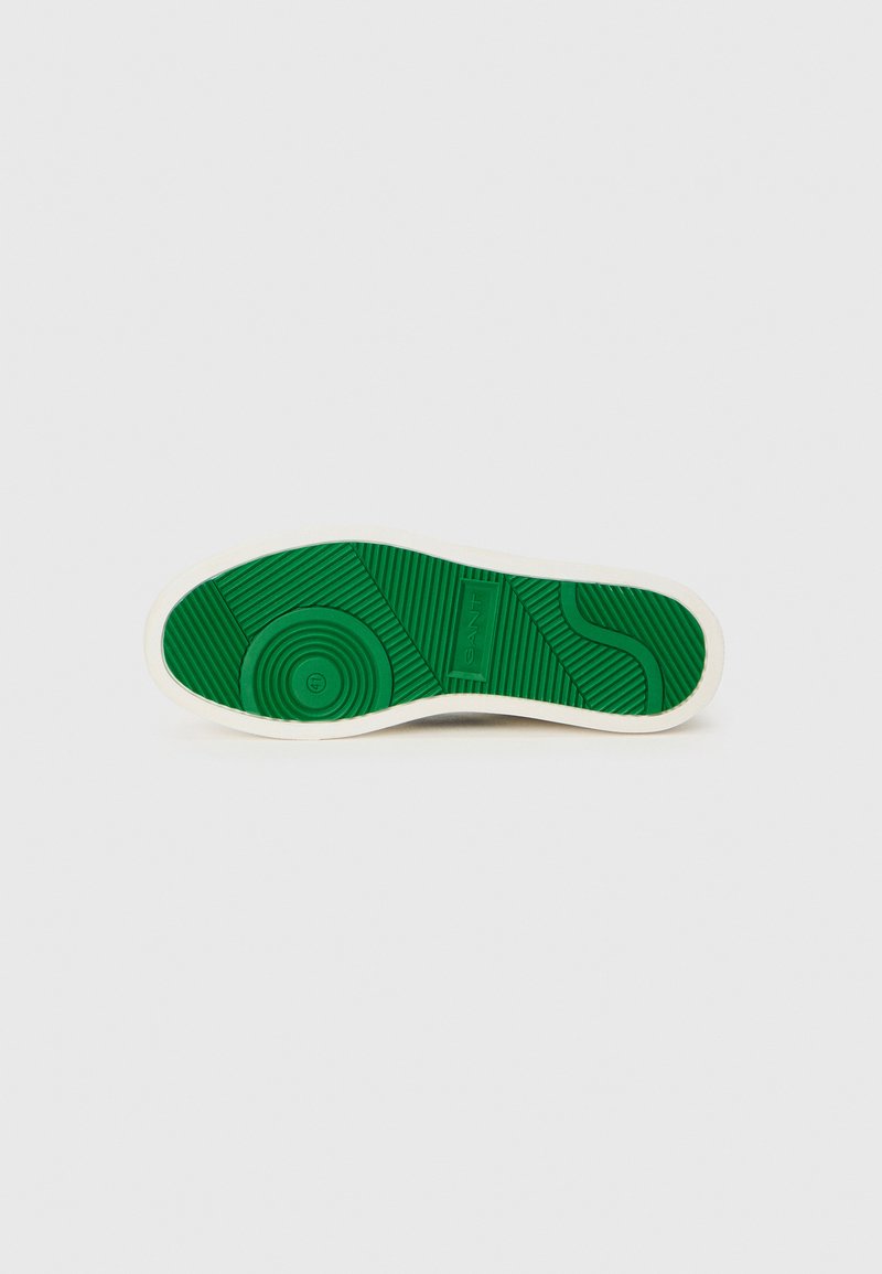 Grüner Gummisohle mit strukturierten Mustern und weißem Rand. Verfügt über kreisförmige und lineare Designs für besseren Halt. Markenname eingraviert.