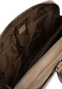 Interno di una borsa a tracolla in pelle beige, con molteplici scomparti e tasche, foderato in tessuto marrone scuro, con un motivo a logo in rilievo.