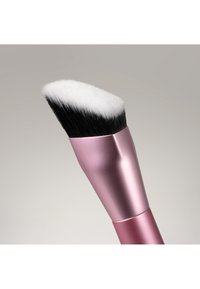Pinceau de maquillage incliné avec des poils synthétiques noirs et blancs densément regroupés et un manche métallique rose sur un fond neutre.