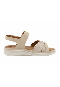 Beige sandal featuring multiple cross straps, a textured fabric accent, a rear ankle strap, and a thick, ridged white sole.
