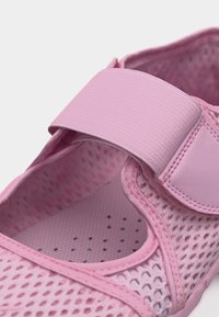 Ροζ αναπνεύσιμο πλέγμα παπουτσιού με ρυθμιζόμενο φαρδύ λουράκι με βέλκρο πάνω για ασφαλή εφαρμογή και άνεση.