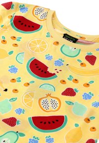 Keltainen organinen puuvillapaita, jossa on värikäs hedelmäkuvio, mukaan lukien vesimeloni, mansikat ja sitruunat, pyöreällä kaula-aukolla.