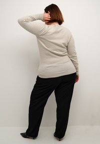 Light gray and white striped sweater with a round neckline, fitted sleeves, and a soft texture, paired with black wide-leg trousers.