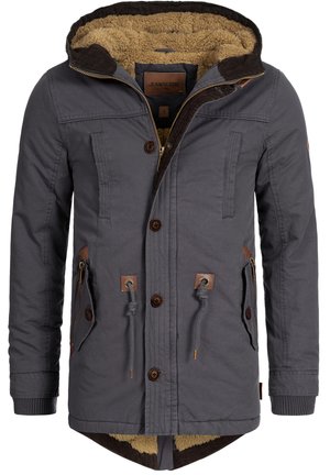 Grå jacka med ett texturerat, brunt fuskpälsfoder. Den har huva med dragsko, dragkedjeförsedda fickor och träknappar. Bruna läderdetaljer.