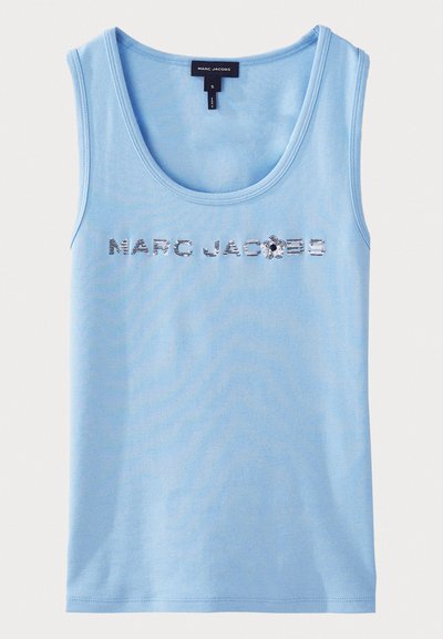 Heleheles sinine puuvillane tank top, millel on sügava kaelusega ja varrukateta disain. Ees on säravad kristallid, millel on kirjutatud "MARC JACOBS".