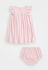 Vaaleanpunainen mekko ja siihen sopivat bloomersit, joissa on röyhelöiset hihat, pystykaitaleet ja kolme nappia takana. Pehmeä, teksturoitu kangas.