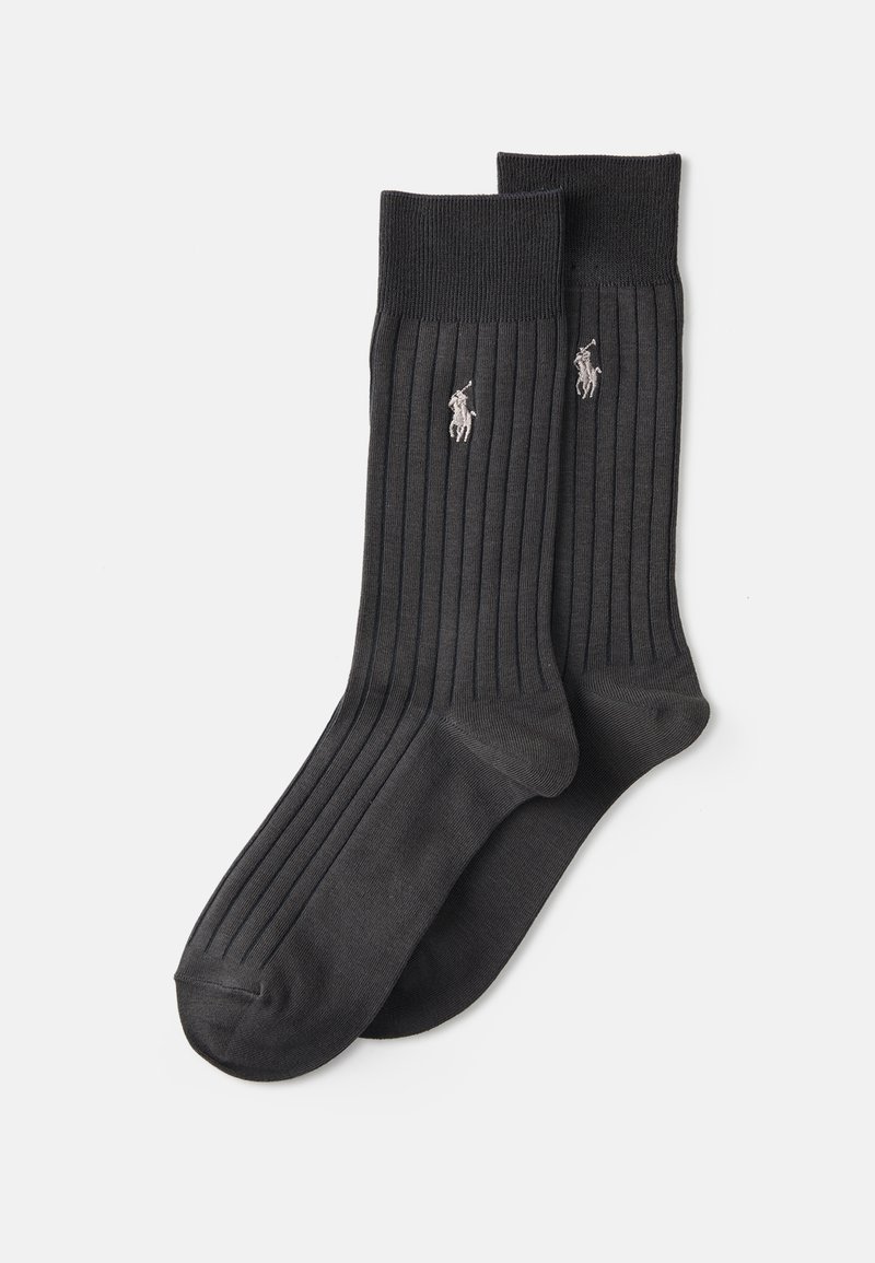 Calcetines de color gris oscuro con un diseño acanalado, hechos de un material suave, que presentan un pequeño logo bordado en gris claro. El diseño incluye una puntera y un talón reforzados.