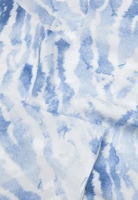 Blå och vit bomullstyg med ett akvarellmönster som har drag och mjuka svängar, med en strukturerad yta.