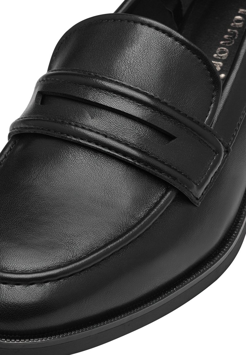 Mocassin en cuir noir avec une finition lisse, présentant une bande à l'avant avec des découpes et un bout arrondi.
