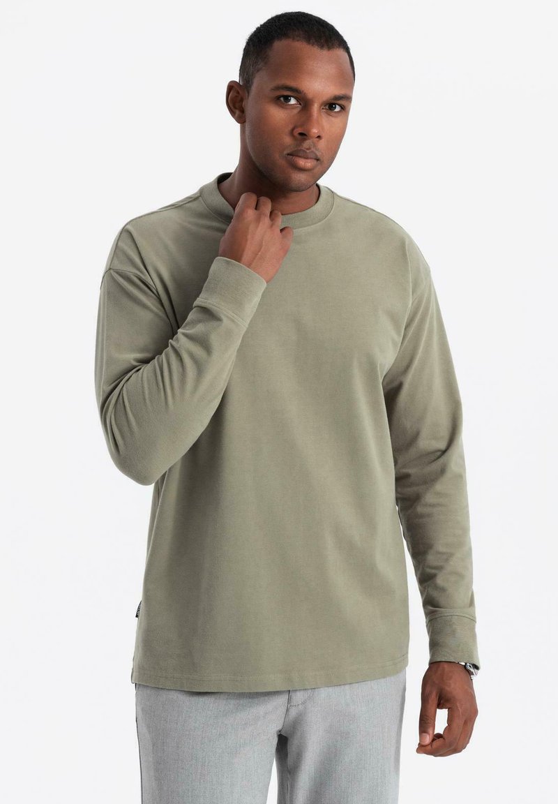 Langarmshirt in olivgrün, aus weichem Material gefertigt. Es hat einen Rundhalsausschnitt und eine lockere Passform, mit minimalistischem Design und ohne Muster.