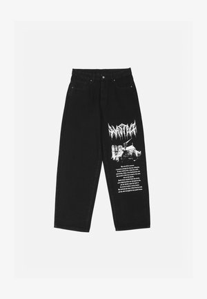 Mustadest denimitest püksid, mis on lõdvema istuvusega. Vasakul jalal valge graafiline trükk, mis sisaldab teksti ja illustratsiooni. Neli taskut, metallist nööpide sulgemine.