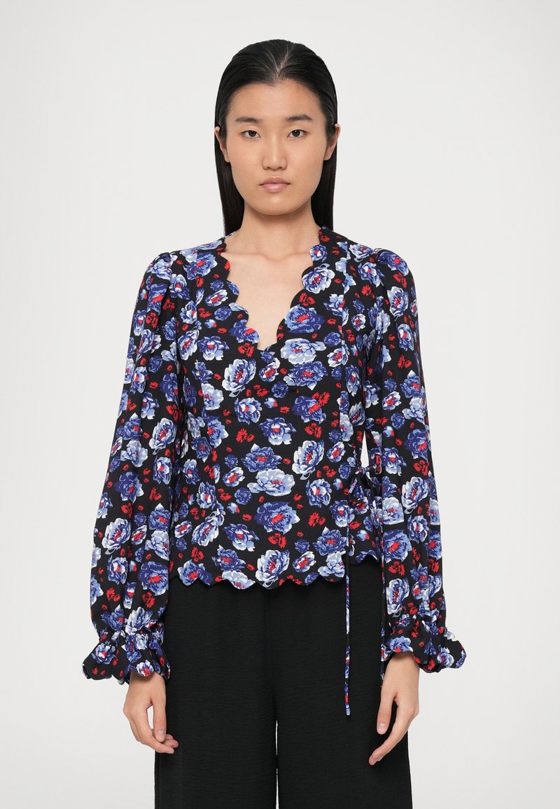 Blusa floreale con scollatura a ondina, maniche lunghe a palloncino e uno sfondo nero con motivi floreali blu e rossi. Legatura in vita.
