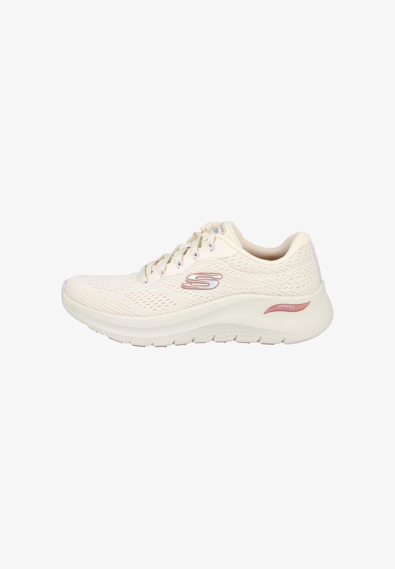 Zapatilla deportiva de color beige claro con parte superior de malla, parte delantera con cordones, suela Arch Fit acolchada y logotipo metálico en el lateral.