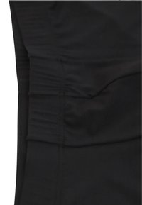 Leggings sportivi neri caratterizzati da un tessuto liscio e elastico, una vita elasticizzata e dettagli arricciati discreti sui lati.
