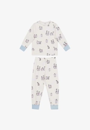 Ensemble de pyjama deux pièces en tissu crème doux. Le haut présente des manches longues et un motif de pingouin ; le pantalon a une taille élastique et un design assorti.