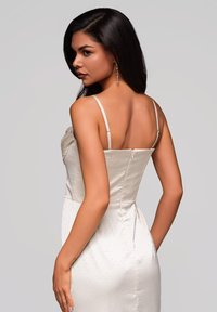 Abito in satin off-white con silhouette aderente, spalline sottili regolabili e sottili pois testurizzati. Dotato di chiusura con zip sul retro.