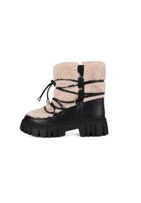 Botas negras de tobillo gruesas con parte superior de piel de oveja beige. Presentan acentos de cuero negro, cordones en contraste y una suela de goma texturizada.