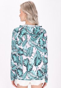 Felpa con maniche lunghe e cappuccio, caratterizzata da un motivo di foglie tropicali in verde e nero su uno sfondo rosa. Leggera, con vestibilità rilassata e cappuccio.