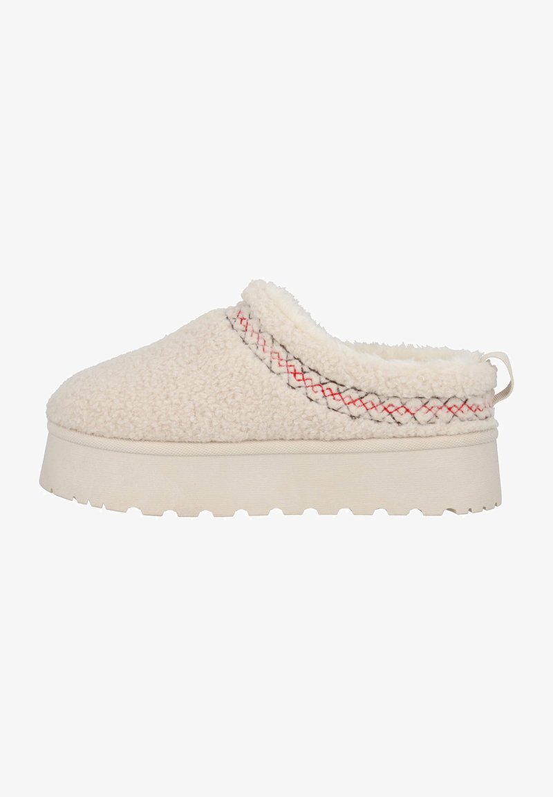 Zapatilla de color crema con un upper suave y texturizado, detalle de costura en rojo y negro contrastante, y una gruesa suela de plataforma blanca.