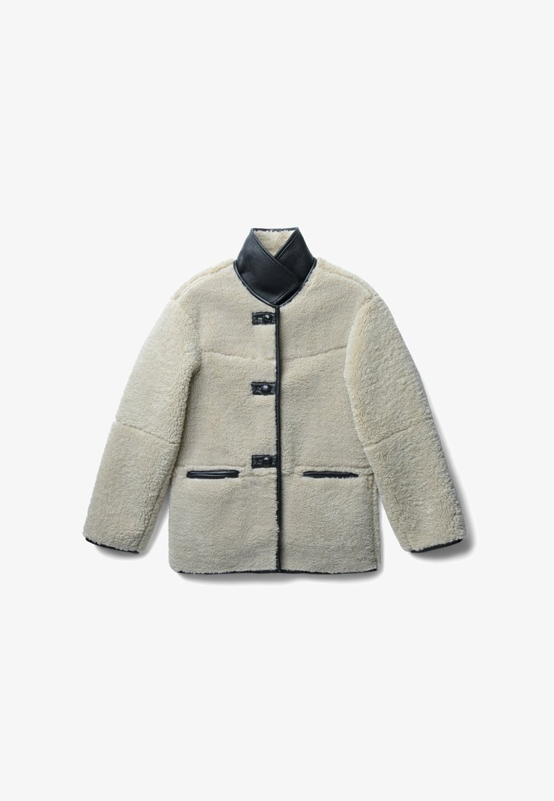 Cremefarbene Lammfelljacke mit einem schwarzen Lederkragen, die vier Knöpfe und schwarze Lederakzente an den Taschen aufweist.