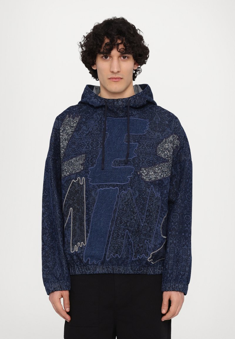 Hoodie en polaire bleu marine avec une capuche à cordon de serrage, présentant un grand texte graphique et des motifs complexes, des poignets élastiques et une coupe ample.