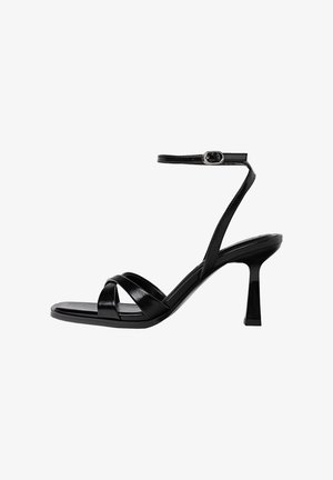 Sandales à talons hauts noires à brides avec un bout carré, en matériau synthétique lisse, sangle de cheville avec une boucle en ton argent et un talon sculpté.