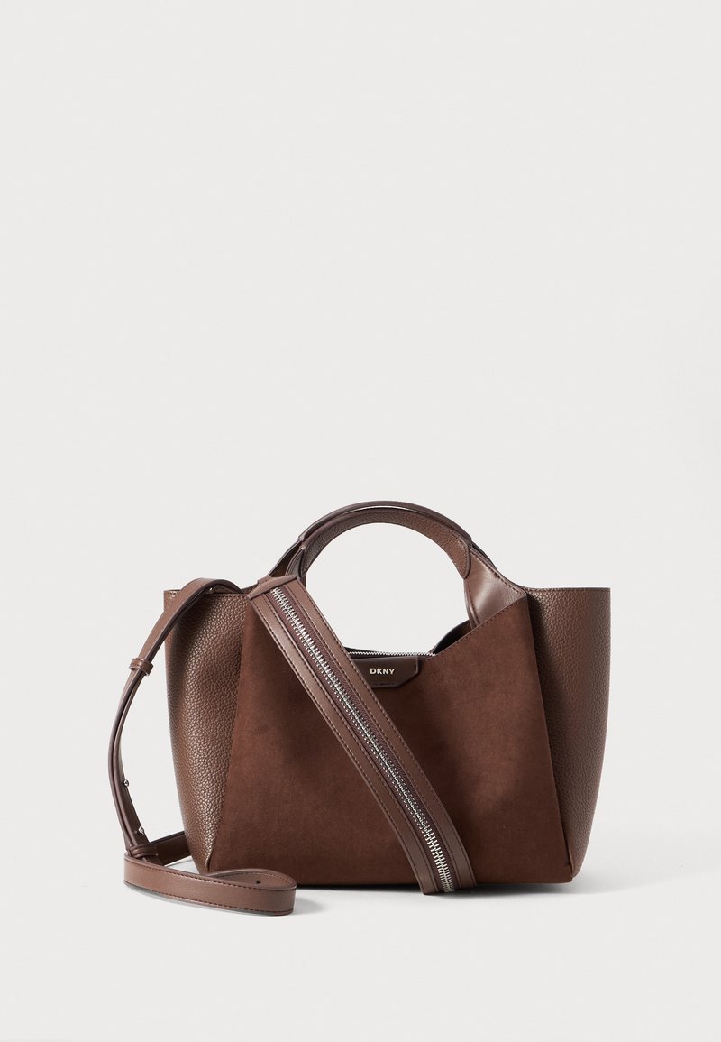Brown handbag combining smooth leather and soft suede with a geometric shape, top handles, and an adjustable strap featuring silver hardware.