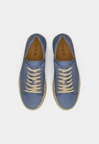 Μπλε πάνινα αθλητικά παπούτσια με μπεζ κορδόνια και υφασμένο σχοινένιο πέλμα. Διαθέτουν στρογγυλεμένη μύτη και άνετο επάνω μέρος χωρίς ραφές. Το όνομα της μάρκας είναι ορατό εσωτερικά.