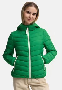 Green puffer jacket with a quilted design, hood, and white zip. Features side pockets and subtle logo on the sleeve.