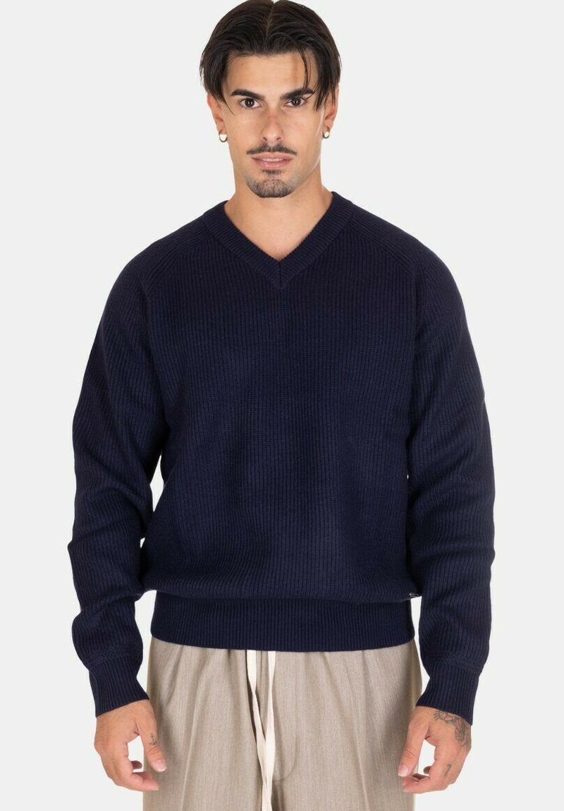 Maglione a coste blu navy con scollatura a V, realizzato in lana, dotato di maniche lunghe e orlo aderente. La texture è morbida e presenta una sottile lucentezza.