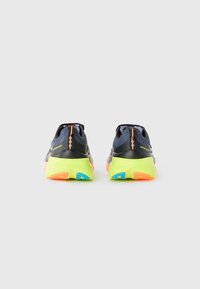 Rear view of athletic shoes featuring a dark blue mesh upper, neon green sole, and multicolored accents in orange and blue.